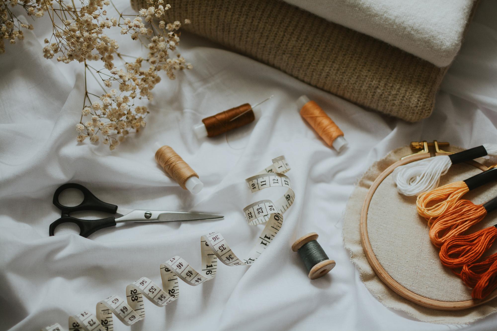 Workshop bench with threads and hand-embroidery tools, natural light